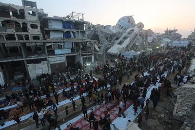 Palestinians break their fast at a table set amidst the destruction and debris caused by Israeli attacks-stock-foto