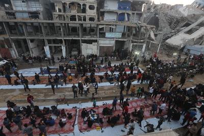 Palestinians break their fast at a table set amidst the destruction and debris caused by Israeli attacks-stock-foto