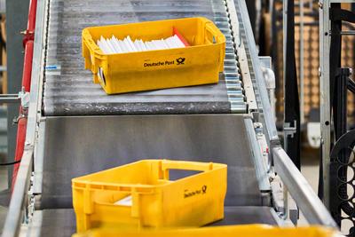 Germering, Bavaria, Germany - 18 March 2025: Yellow Deutsche Post mailboxes travel along a conveyor belt at the mail cen-stock-foto