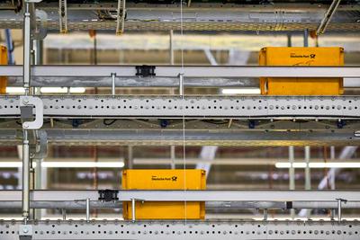 Germering, Bavaria, Germany - 18 March 2025: Deutsche Post s yellow letter boxes move on an automated conveyor belt in a-stock-foto