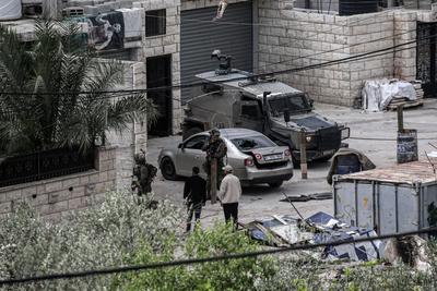 Israeli soldiers detain people as they conduct a raid in the Al-ain camp for Palestinian refugees west of Nablus in the occupied West Bank-stock-foto
