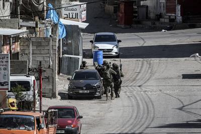 Israeli soldiers detain people as they conduct a raid in the Al-ain camp for Palestinian refugees west of Nablus in the occupied West Bank-stock-foto