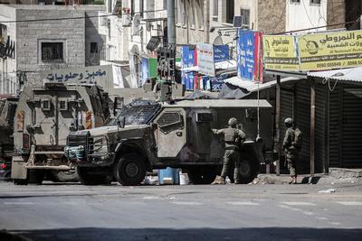Israeli soldiers detain people as they conduct a raid in the Al-ain camp for Palestinian refugees west of Nablus in the occupied West Bank-stock-foto