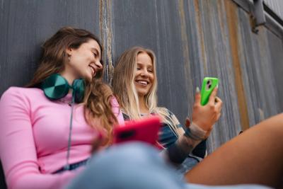 Young stylish generation Z girls spending time together outdoors after school. Young stylish generation Z girls spending-stock-foto