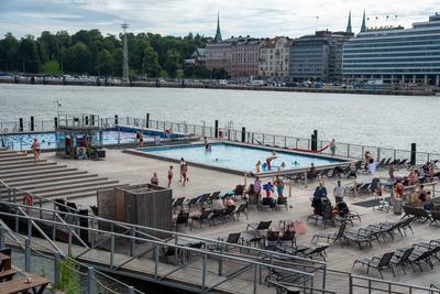 Tourists and locals enjoying a sunny summer day by swimming and sunbathing at swimming pool Helsinki, Finland, July 18 2-stock-photo
