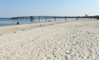Touristen gehen am Donnerstagnachmittag bei Temperaturen ?ber 15 Grad und Windstille ?ber die Maritim Seebr?cke Timmendo-stock-foto