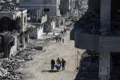 Displaced Palestinians continue to return their houses past heavily damaged and partially collapsed buildings after the ceasefire and hostage-prisoner swap deal between Hamas and Israel at Bureij-stock-foto