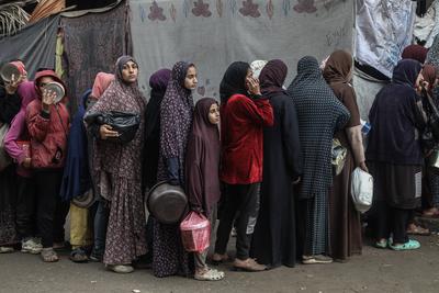 Palestinians gather to receive food cooked by a charity kitchen amid a hunger crisis as the Israel-Gaza-stock-foto