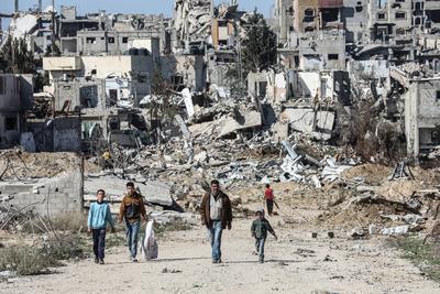 Displaced Palestinians continue to return their houses past heavily damaged and partially collapsed buildings after the ceasefire and hostage-prisoner swap deal between Hamas and Israel at Bureij-stock-foto