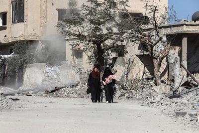 Displaced Palestinians continue to return their houses past heavily damaged and partially collapsed buildings after the ceasefire and hostage-prisoner swap deal between Hamas and Israel at Bureij-stock-foto