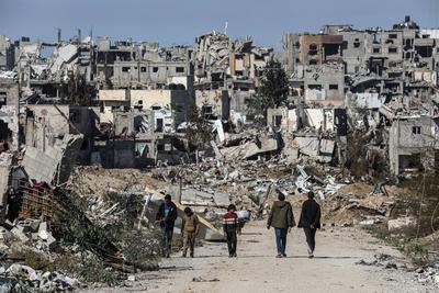 Displaced Palestinians continue to return their houses past heavily damaged and partially collapsed buildings after the ceasefire and hostage-prisoner swap deal between Hamas and Israel at Bureij-stock-foto