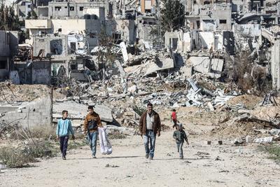 Displaced Palestinians continue to return their houses past heavily damaged and partially collapsed buildings after the ceasefire and hostage-prisoner swap deal between Hamas and Israel at Bureij-stock-foto