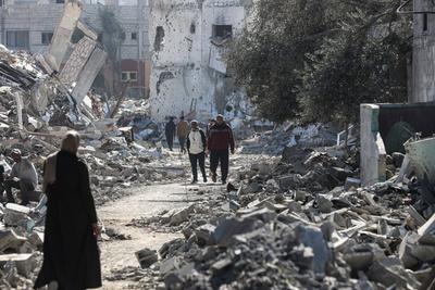 Displaced Palestinians continue to return their houses past heavily damaged and partially collapsed buildings after the ceasefire and hostage-prisoner swap deal between Hamas and Israel at Bureij-stock-foto