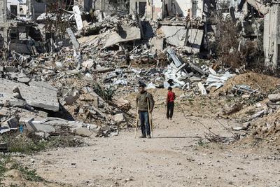 Displaced Palestinians continue to return their houses past heavily damaged and partially collapsed buildings after the ceasefire and hostage-prisoner swap deal between Hamas and Israel at Bureij-stock-foto