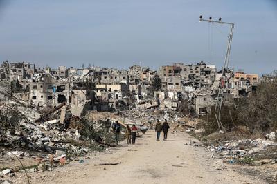 Displaced Palestinians continue to return their houses past heavily damaged and partially collapsed buildings after the ceasefire and hostage-prisoner swap deal between Hamas and Israel at Bureij-stock-foto