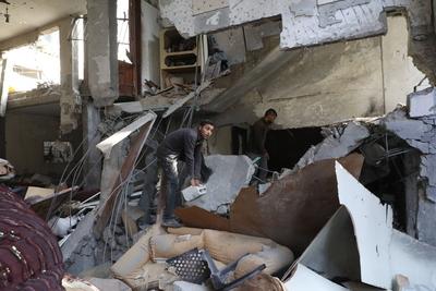 Residents stand near a destroyed  a house hit by Israeli bombardment at the Bureij refugee camp-stock-foto