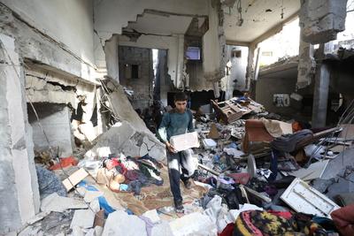 Residents stand near a destroyed  a house hit by Israeli bombardment at the Bureij refugee camp-stock-foto