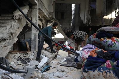 Residents stand near a destroyed  a house hit by Israeli bombardment at the Bureij refugee camp-stock-foto