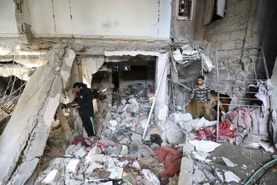 Residents stand near a destroyed  a house hit by Israeli bombardment at the Bureij refugee camp-stock-foto