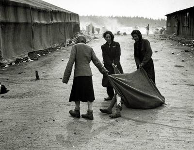 KZ Bergen-Belsen Die Insassen ziehen den K?rper eines Kranken mit einer Decke nach der ?bergabe des Lagers an die Allie-stock-foto
