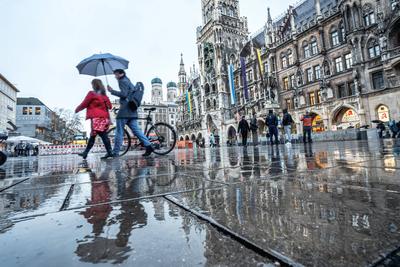 Wolkenbruch und Gewitter, Passanten eilen mit Regenschirm ?ber den leeren Marienplatz, M?nchen, M?rz 2025-stock-foto