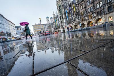 Wolkenbruch und Gewitter, Passantin eilt mit Regenschirm ?ber den leeren Marienplatz, M?nchen, M?rz 2025-stock-foto