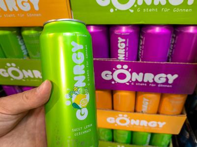 Bavaria, Germany - July 10, 2024: Customer holding a G?nrgy beverage can in a food supermarket. Energy drink from the Ge-stock-foto