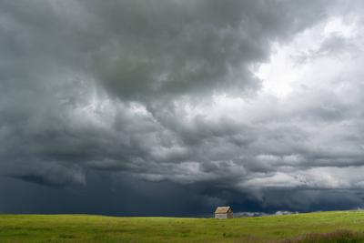 Lonely abandoned barn facing incoming supercell storm in the great plains-stock-photo
