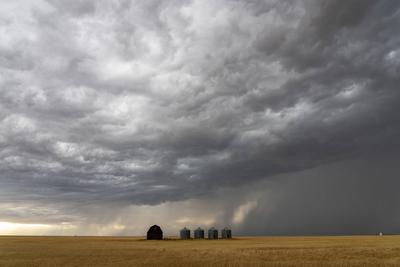 Dramatic supercell storm clouds forming over a farm in the plains-stock-photo