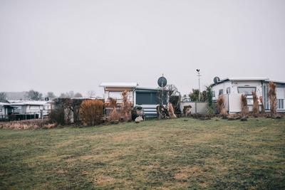 Quiet camping area with mobile homes and grassy landscape at Sehlendorfer Strand. *** Quiet camping area with mobile hom-stock-photo