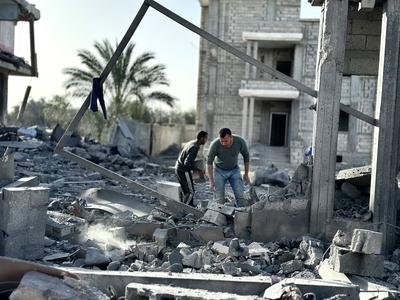Palestinians inspect the area after Israeli attack over Khan Yunis-stock-photo