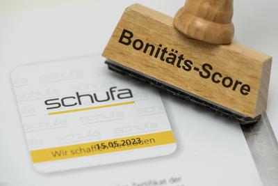 SCHUFA Bonit?tsauskunft Ein Holzstempel mit Aufdruck Bonit?ts-Score steht auf einem Formular der SCHUFA Bonit?tsauskunft-stock-foto