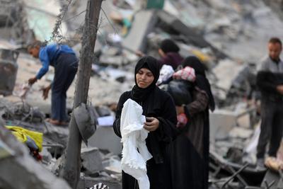 Palestinians try to salvage some items in the devastated yard of a schoo-stock-foto