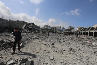 Palestinians try to salvage some items in the devastated yard of a schoo-stock-foto