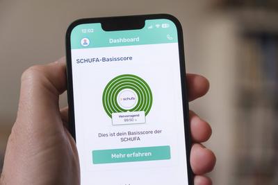 Die App Bonify zeigt auf einem Mobiltelefon den SCHUFA-Basisscore. Im vorliegenden Beispiel liegt er bei 99,50 % und ist damit hervorragend *** The Bonify app shows the SCHUFA basic score on a mobile phone. In this example, it is 99.50 % and is therefore excellent-stock-foto