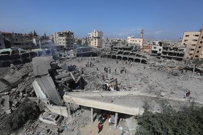 Palestinians try to salvage some items in the devastated yard of a schoo-stock-foto