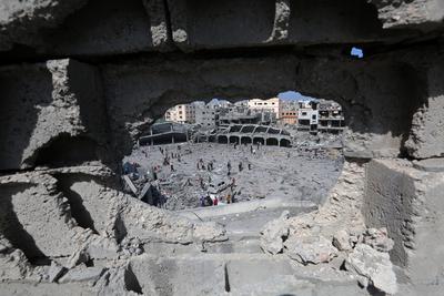 Palestinians try to salvage some items in the devastated yard of a schoo-stock-foto