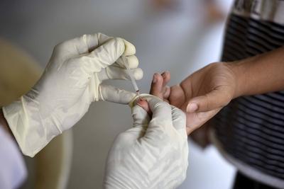 GURUGRAM, INDIA - SEPTEMBER 11: A health worker collects a blood sample from a woman to test for malaria, at the Communi-stock-photo