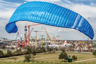 bauma 2025, weltweit gr??te Baumaschinenmesse, Blick vom Riemer Park auf die unz?hligen Kr?nen, vorne trainiert ein Gleitschirmflieger, M?nchen, 5. April 2025-stock-photo