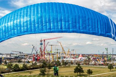 bauma 2025, Blick vom Riemer Park auf die unz?hligen Kr?nen, vorne trainiert ein Gleitschirmflieger, weltweit gr??te Baumaschinenmesse, M?nchen, 5. April 2025-stock-photo