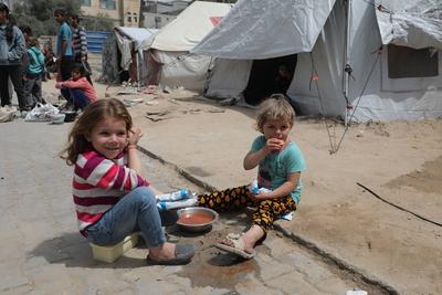 Palestinians, including women and children, scramble to collect food during a distribution by the charity organization-stock-photo