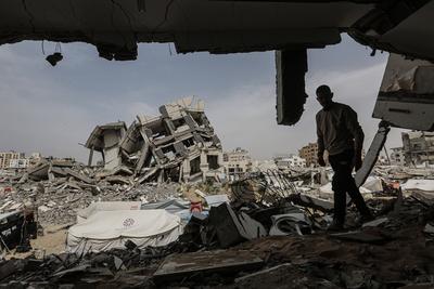 Palestinians try to go about their daily lives amid the rubble of buildings or their makeshift tents-stock-foto