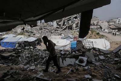 Palestinians try to go about their daily lives amid the rubble of buildings or their makeshift tents-stock-foto