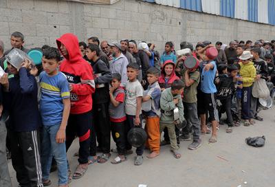 Palestinians gather in large numbers to receive the meals distributed by charities in the Nuseirat refugee camp, in the central part of Gaza-stock-photo
