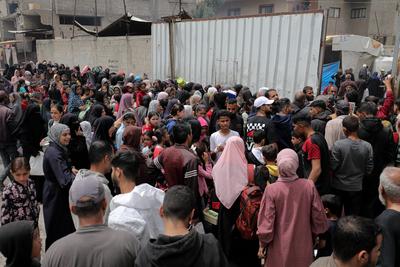 Palestinians gather in large numbers to receive the meals distributed by charities in the Nuseirat refugee camp, in the central part of Gaza-stock-photo