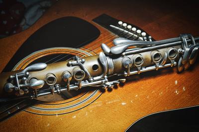 Detail einer antiken Klarinette, die auf einer akustischen Gitarre ruht *** Detail a antique Clarinet, the at a acoustic-stock-photo