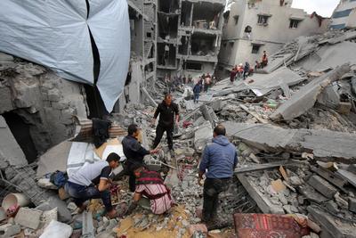 Palestinians inspect the rubble of a building following an Israeli strike on a residential area in Gaza City's Shujaiyya-stock-foto