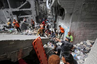 Palestinians inspect the rubble of a building following an Israeli strike on a residential area in Gaza City's Shujaiyya-stock-foto