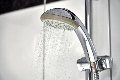 Germany - March 4, 2025: Water flows out of a shower head in a bathroom shower *** Wasser flie?t aus einem Duschkopf in-stock-foto