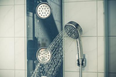 21 August 2022: Water flows from a shower head in a shower *** Wasser flie?t aus einem Duschkopf in einer Dusche-stock-photo